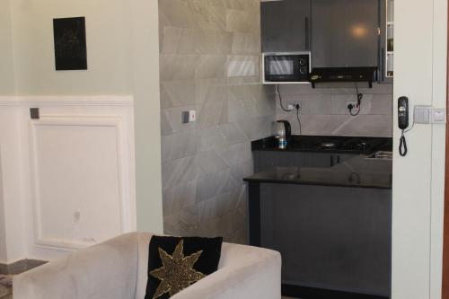 a kitchen with a white chair with a gold star on it at ISN Luxury Apartments in Dodoma