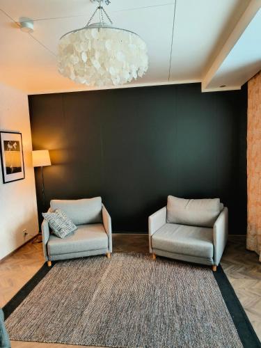 - un salon avec deux chaises et un mur noir dans l'établissement Viettola, à Pielavesi