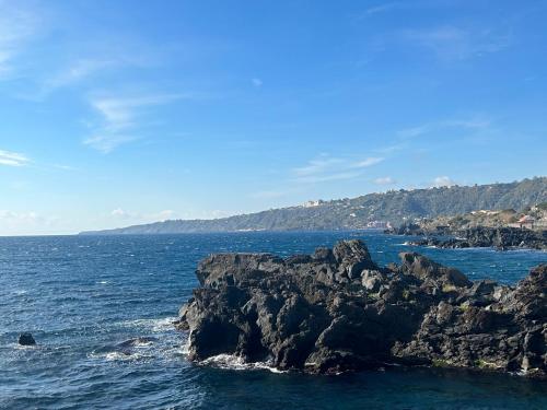 a view of the ocean with a rocky coastline at B&B Ai piedi dell'Etna in Acireale