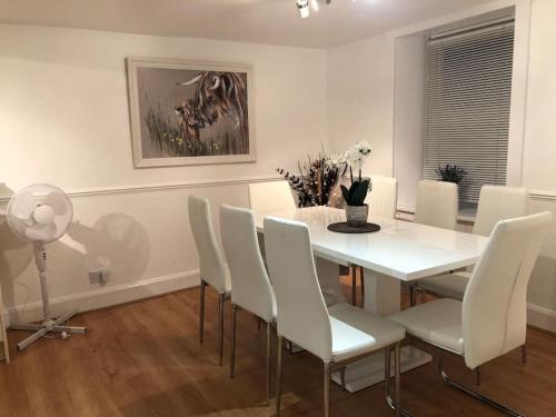 a white dining room with a white table and chairs at Lochside Retreat, Stranraer - Cottage by the loch! in Stranraer