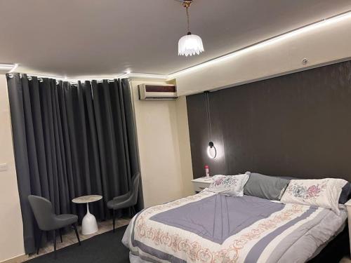 1 dormitorio con 1 cama, mesa y sillas en شقة غرفة وصالة بلكونه دخول ذكي, en Riad
