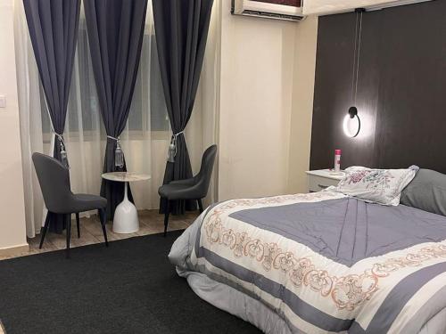 شقة غرفة وصالة بلكونه دخول ذكي في الرياض: غرفة نوم بسرير وكرسيين وطاولة