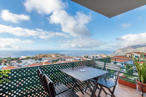 einen Tisch und Stühle auf einem Balkon mit Aussicht in der Unterkunft Barcelos Apartment by HR Madeira in Funchal