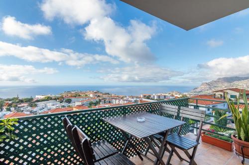 een tafel en stoelen op een balkon met uitzicht bij Barcelos Apartment by Holiday Rental Madeira in Funchal