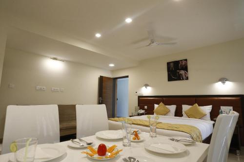 a hotel room with a bed and a table and chairs at D Breeze Suites in Devanahalli-Bangalore