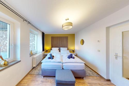two beds in a room with two windows at CozyHome Hauptmarkt Apartments in Gotha