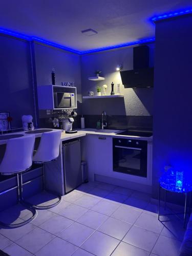 une cuisine avec éclairage bleu dans une cuisine avec comptoirs dans l'établissement « Le Boudoir d’Elodie » le Spa Romantique, à Saint-Léonard