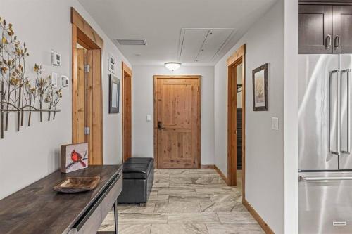 a kitchen with a table and a refrigerator at Spring Creek Spacious Luxury & Views at White Spruce Lodge in Canmore