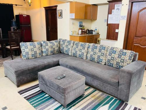 a gray couch in a living room with a table at Backpackers Hostel Islamabad in Islamabad