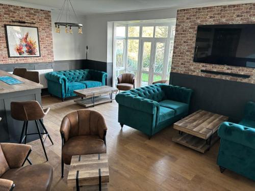 uma sala de espera com sofás e cadeiras azuis em The Havelock em Shanklin