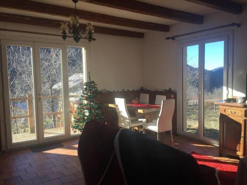 un salon avec une table, des chaises et des fenêtres dans l'établissement Chalet de Montagne, à Valdeblore