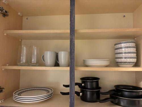 a pantry with plates and dishes on shelves at Manor House in Belfast