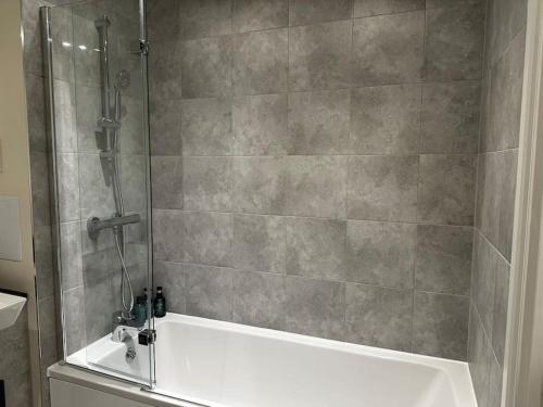 a shower with a white tub in a bathroom at Luxury Apt in Wembley Park Perfect for Events & Exploring London in London