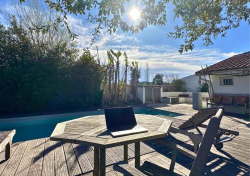 einen Laptop auf einem Picknicktisch auf einer Terrasse in der Unterkunft Villa COLIVING EFFET MER - Nomad Digital - 4 chambres in Anglet