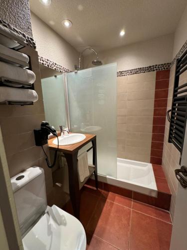 La salle de bains est pourvue d'un lavabo, d'une baignoire et de toilettes. dans l'établissement Hôtel Spa La Truite Dorée, à Vers