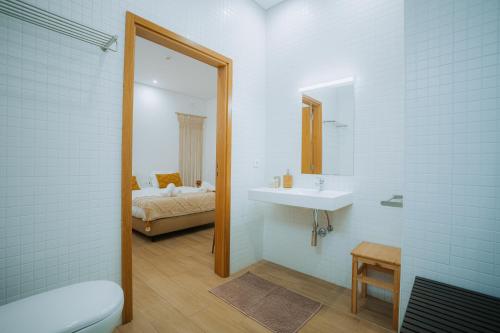a bathroom with a sink and a mirror and a bed at Estação do Parque in Santa Maria Da Feira