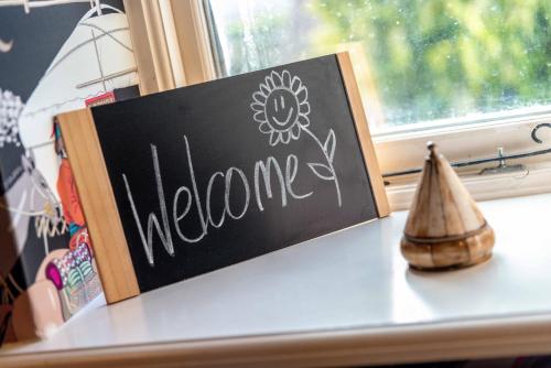 a chalkboard sign on a shelf next to a window at Luxurious, Fabulous, Fun, Contemporary Suite in Retreat Centre in Salisbury
