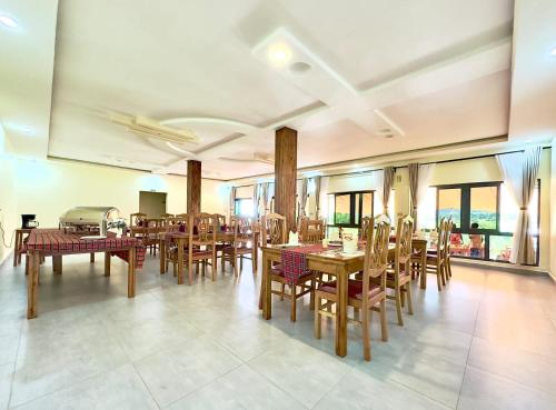uma sala de jantar com mesas e cadeiras de madeira em OLORIEN MARA CAMP em Masai Mara
