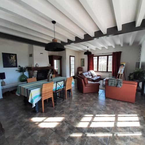 un salon avec une table et un canapé dans l'établissement Maison landaise de famille, à Josse