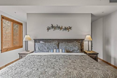 a bedroom with a large bed and two lamps at Spring Creek Spacious Luxury & Views at White Spruce Lodge in Canmore
