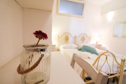 un vaso con un fiore su un tavolo in una camera da letto di Casa Aleatico Residence Torre Santo Stefano in Otranto ad Alimini