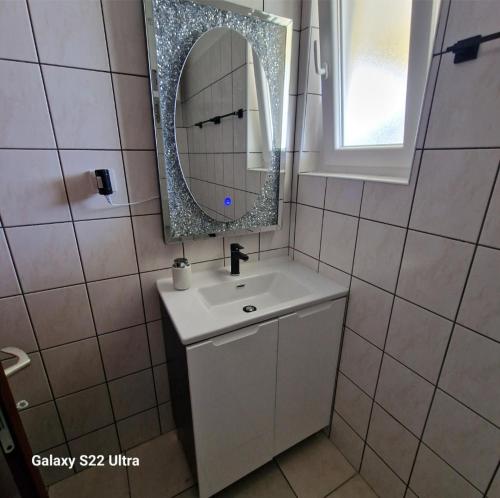 een badkamer met een wastafel en een spiegel bij Villa Renata in Privlaka