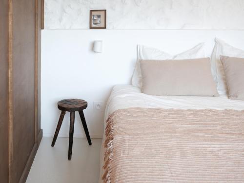 a bedroom with a bed with a stool next to it at Maison Magda in Ambierle