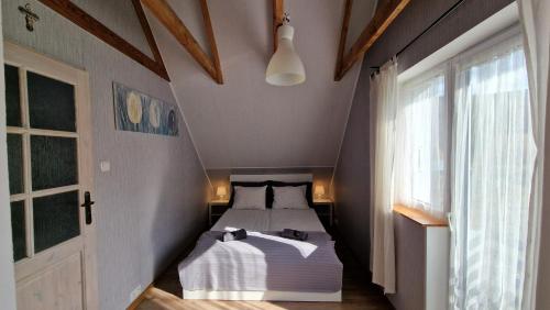 een slaapkamer met een bed in een kamer met een raam bij Parysówka Noclegi w Rzeczce Góry Sowie in Walim