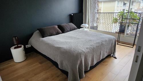 une chambre avec un lit dans une pièce avec une fenêtre dans l'établissement Le Bord de Seine - Paris, à Paris