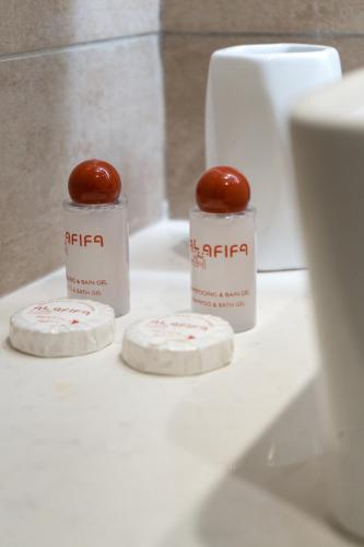 two bottles of ketchup sitting on a bathroom counter at Hôtel AL AFIFA in Dakar