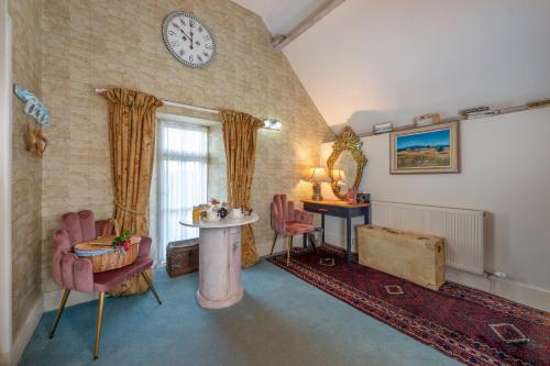 a living room with a clock on the wall at Luxurious, Fabulous, Fun, Contemporary Suite in Retreat Centre in Salisbury