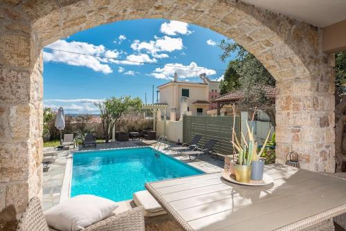 an archway over a swimming pool in a house at Διαμέρισμα με πισίνα στην Αρτέμιδα in Vravrona