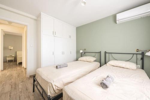 two beds sitting next to each other in a bedroom at Διαμέρισμα με πισίνα στην Αρτέμιδα in Vravrona