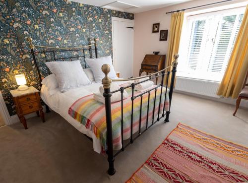 a bedroom with a bed with a floral wallpaper at Dene Croft Cottage in Hexham
