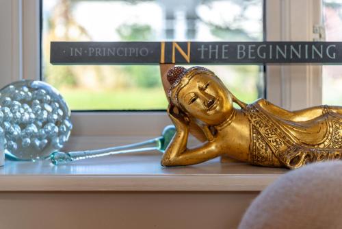 Eine goldene Statue einer Frau, die Golf spielt. in der Unterkunft Luxurious, Fabulous, Fun, Contemporary Suite in Retreat Centre in Salisbury