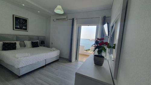 1 dormitorio con cama y vistas al océano en Hotel Ceko, en Sarandë