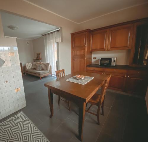 eine Küche und ein Esszimmer mit einem Holztisch und Stühlen in der Unterkunft Apartment L'Envers in Aosta