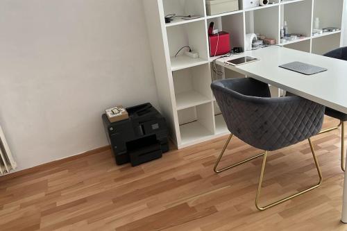 ein Büro mit einem Schreibtisch und einem Stuhl in der Unterkunft Wels Bahnhoft Stadt 80qm Apartment in Wels