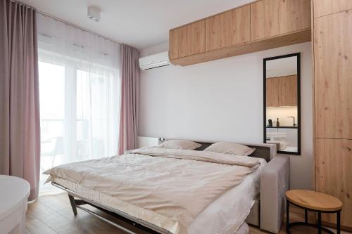 a bedroom with a bed and a mirror and a tub at Studio nad rzeką 72, Rynek 500 m in Wrocław