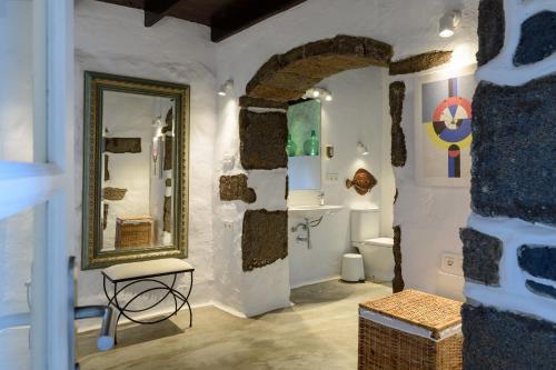 a bathroom with a mirror and a sink and a toilet at La Casa del Medianero in Mácher