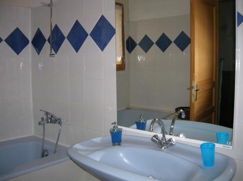 a bathroom with a sink and a tub and a mirror at Le Mas des Baux in Bédoin