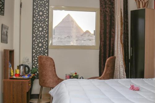 um quarto com uma cama e vista para as pirâmides em pyramids light show em Cairo