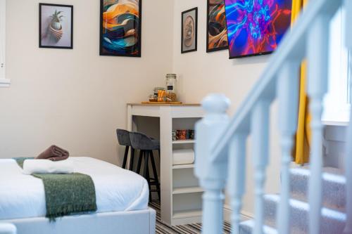 una camera con letto e una scala con dipinti di Highbury & Islington Hub a Londra