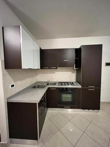 una cucina con armadi marroni e piano cottura. di Sottomarina Sabbia e Sale a Sottomarina