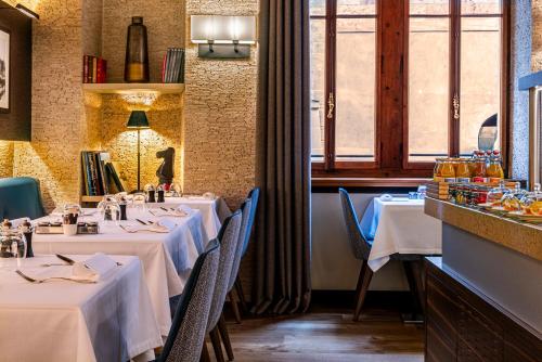 a restaurant with two tables with white tablecloths at Hôtel Les Armures in Geneva