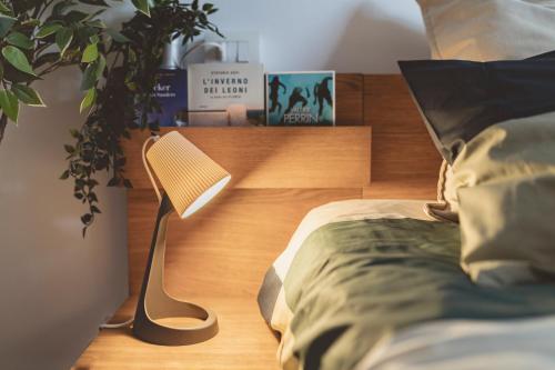 ein Schlafzimmer mit einem Bett mit einer Lampe und einer Anlage in der Unterkunft Casa Zoe 2 Apartment(Parking,Self Check-in & Wi-Fi) in Parma