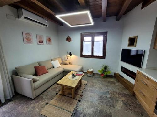 ein Wohnzimmer mit einem Sofa und einem Couchtisch in der Unterkunft El Pajar de la Plaza in Guaso