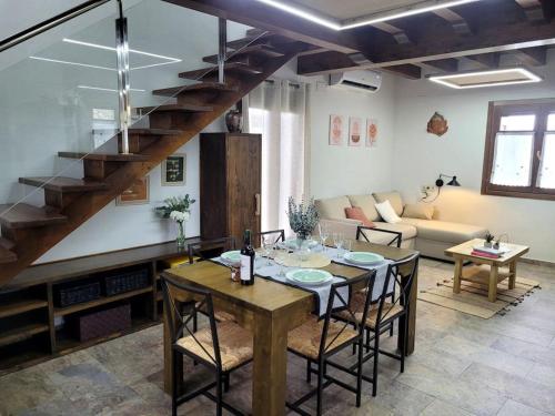 ein Wohnzimmer mit einem Tisch und einer Treppe in der Unterkunft El Pajar de la Plaza in Guaso