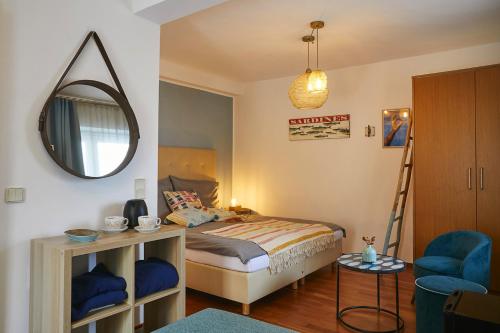 a bedroom with a bed and a mirror and a chair at Beachhaus Velden in Velden am Wörthersee