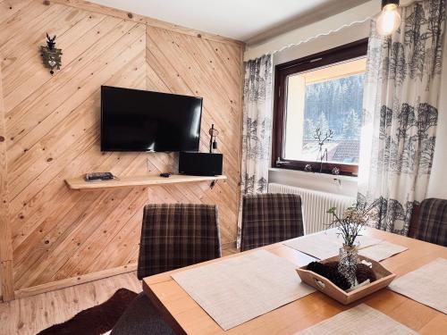 ein Esszimmer mit einem Tisch und einem TV an der Wand in der Unterkunft Schwarzwald-Hotel Kraeutle in Feldberg